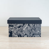 Artistic storage chest with black and ivory botanical details for elegant room décor.