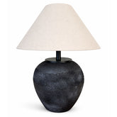 A bold black ceramic table lamp with distinctive granular finish and sculpted form.