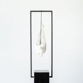 Art resin sculpture of man suspended in black metal frame
