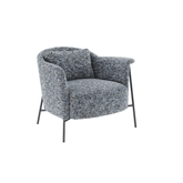 Modern armchair upholstered in soft chenille fabric with grey powder-coated metal legs and a sculptural, curved silhouette.