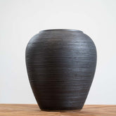 Small black ceramic planter with textured surface, weather-resistant and featuring a drainage hole, perfect for indoor or outdoor décor.