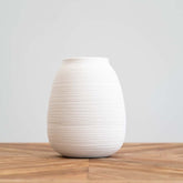 Handmade white textured vase featuring linear detailing, ideal for displaying fresh or dried flowers in minimalist interiors.