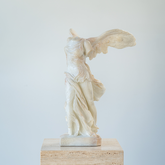 Resin statue of the Winged Victory of Samothrace featuring detailed wings and flowing drapery in a dynamic pose.