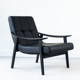 Hudson lounge chair with black ash wood frame and premium faux leather seat, modern accent chair for living rooms