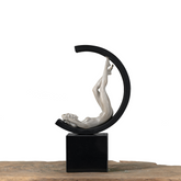 Modern marble and resin sculpture of a graceful female figure positioned inside a half-circle ring on a black stand, blending classical beauty with contemporary design.