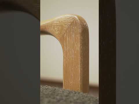 Video showcasing the Estrid Accent Armchair with solid oak frame, bouclé-style grey upholstery, silk underlay, and angled ladder-back design, highlighting its Scandinavian-inspired modern style and comfort.