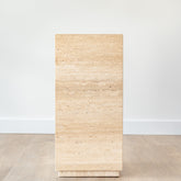 Minimalist travertine display stand featuring warm earth tones and clean lines, placed in a contemporary space.