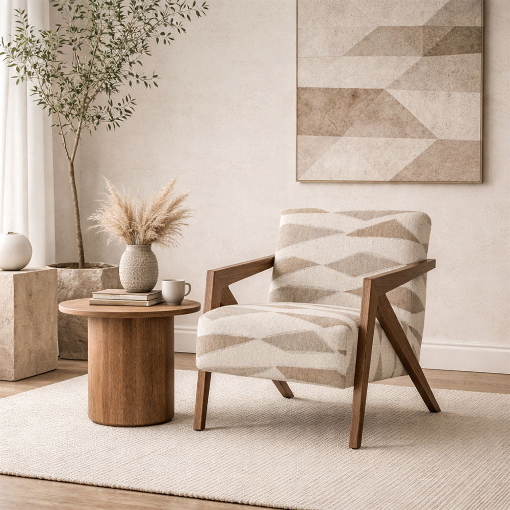 Modern living room with a patterned armchair, wooden side table, and geometric wall art.