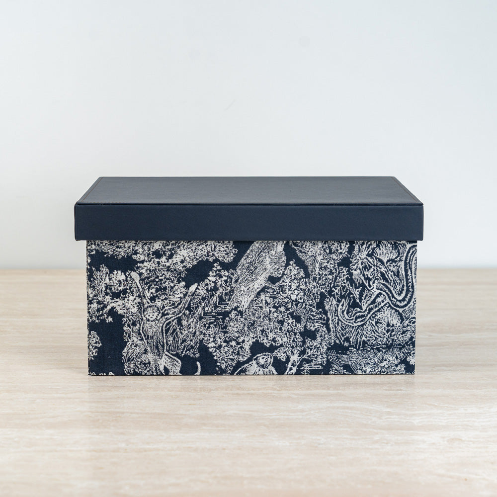Artistic storage chest with black and ivory botanical details for elegant room décor.