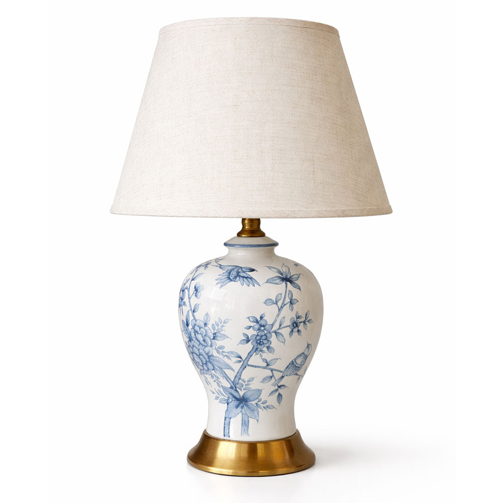 A timeless blue and white ceramic table lamp with delicate floral and bird detailing