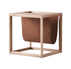 The Brace Side Table showcasing a sturdy elm wood frame paired with built-in leather book storage for stylish organization.