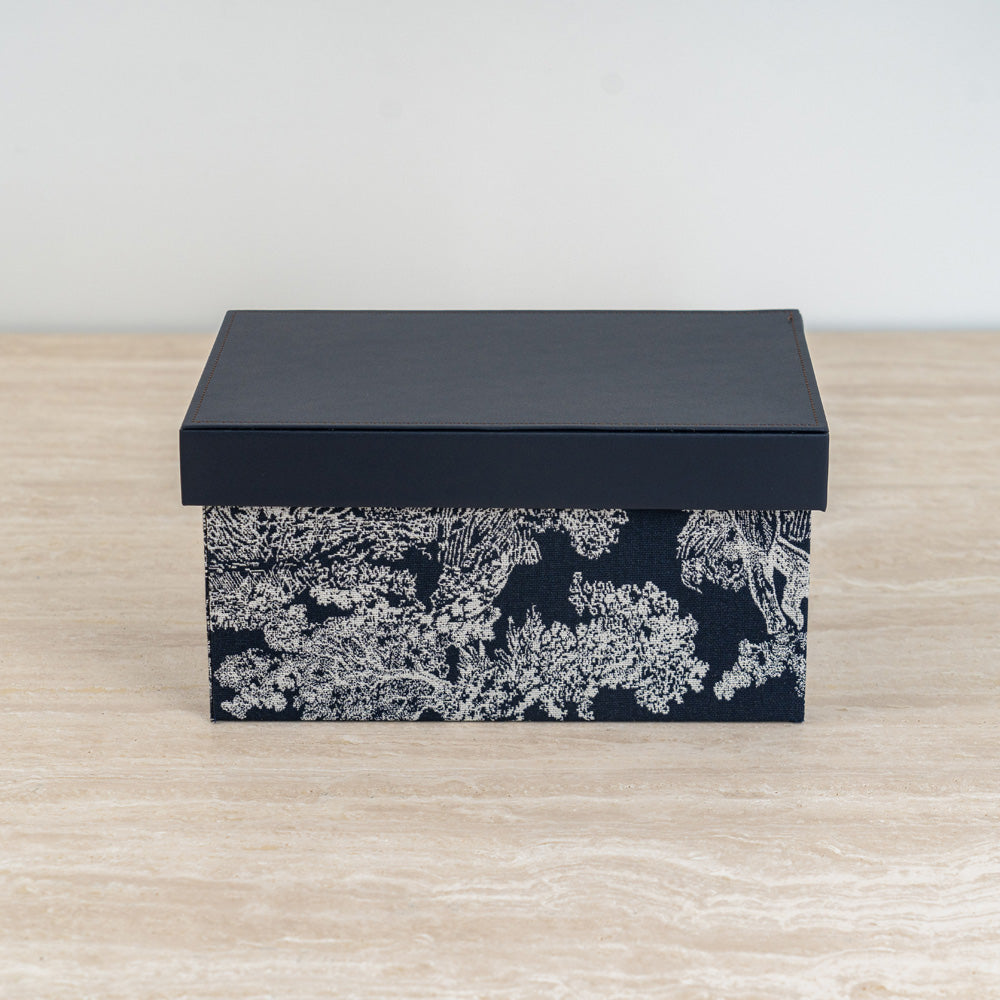 Elegant black and ivory botanical storage box with dark lid for modern home organization.