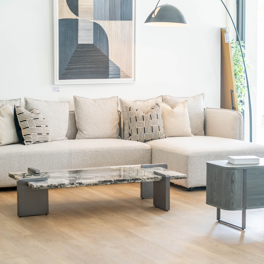 Elegant L-shaped sofa featuring high-quality fabric, plush cushioning, and sleek metal legs for contemporary interiors.
