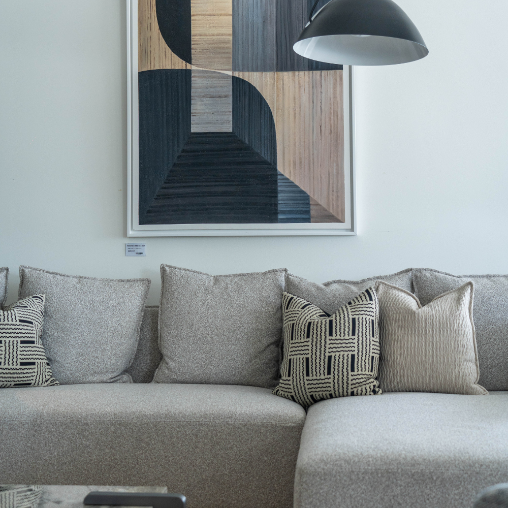 Stylish modern corner sofa upholstered in soft fabric with intricate arm design, perfect for living room or open-plan spaces.