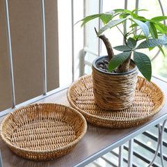 Sophisticated round plastic rattan plate basket, perfect for modern, traditional, or contemporary interiors.