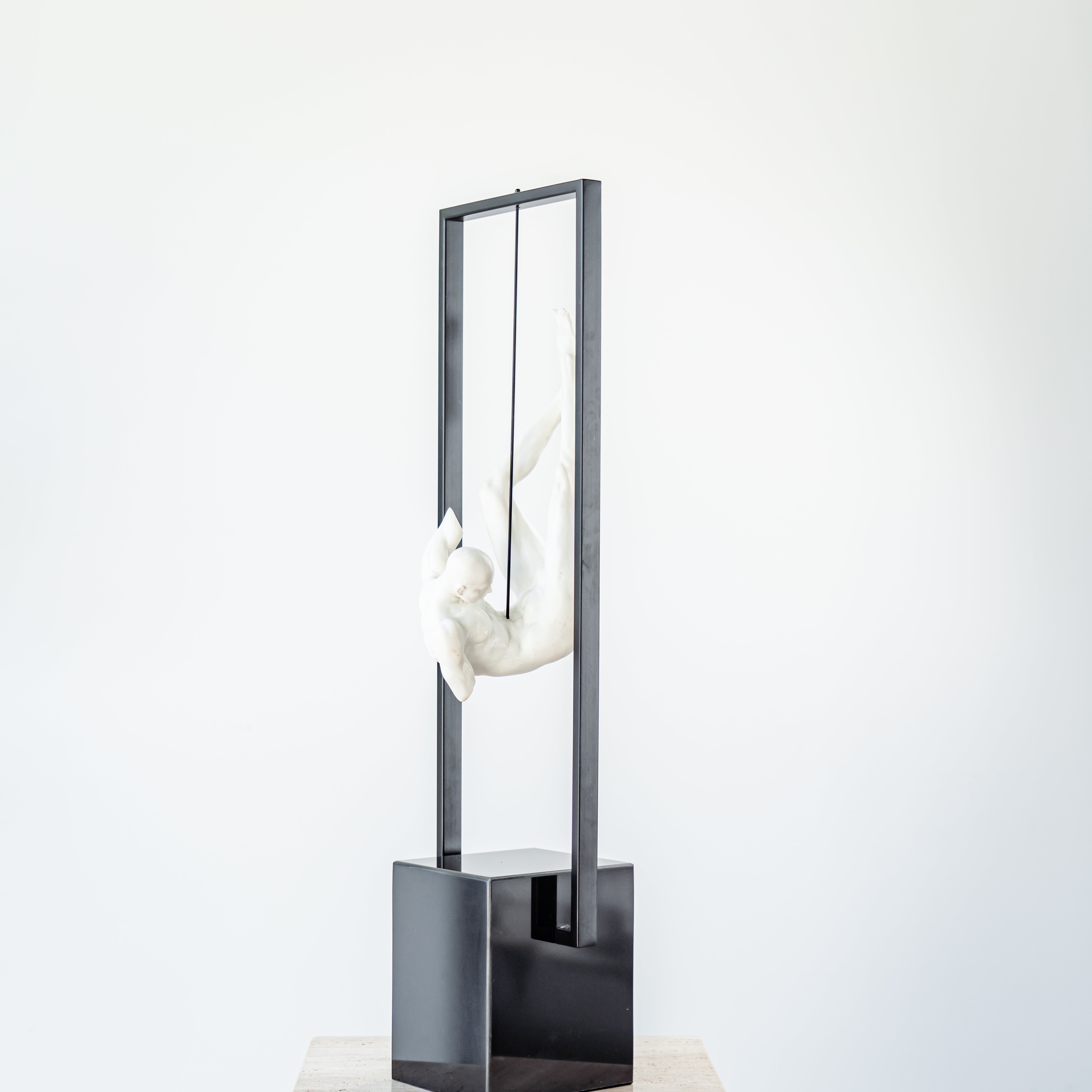 Suspended male figure sculpture with smooth resin and metal contrast
