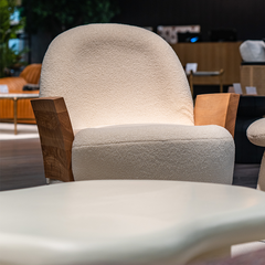 Stylish upholstered chair combining soft chenille fabric and textured wood craftsmanship.