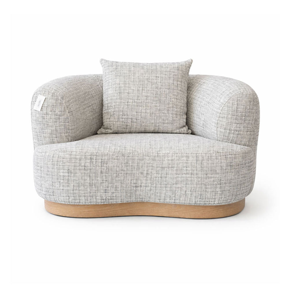 Modern curved armchair upholstered in soft grey textured fabric, featuring a sculptural silhouette designed for contemporary living rooms and stylish interiors.