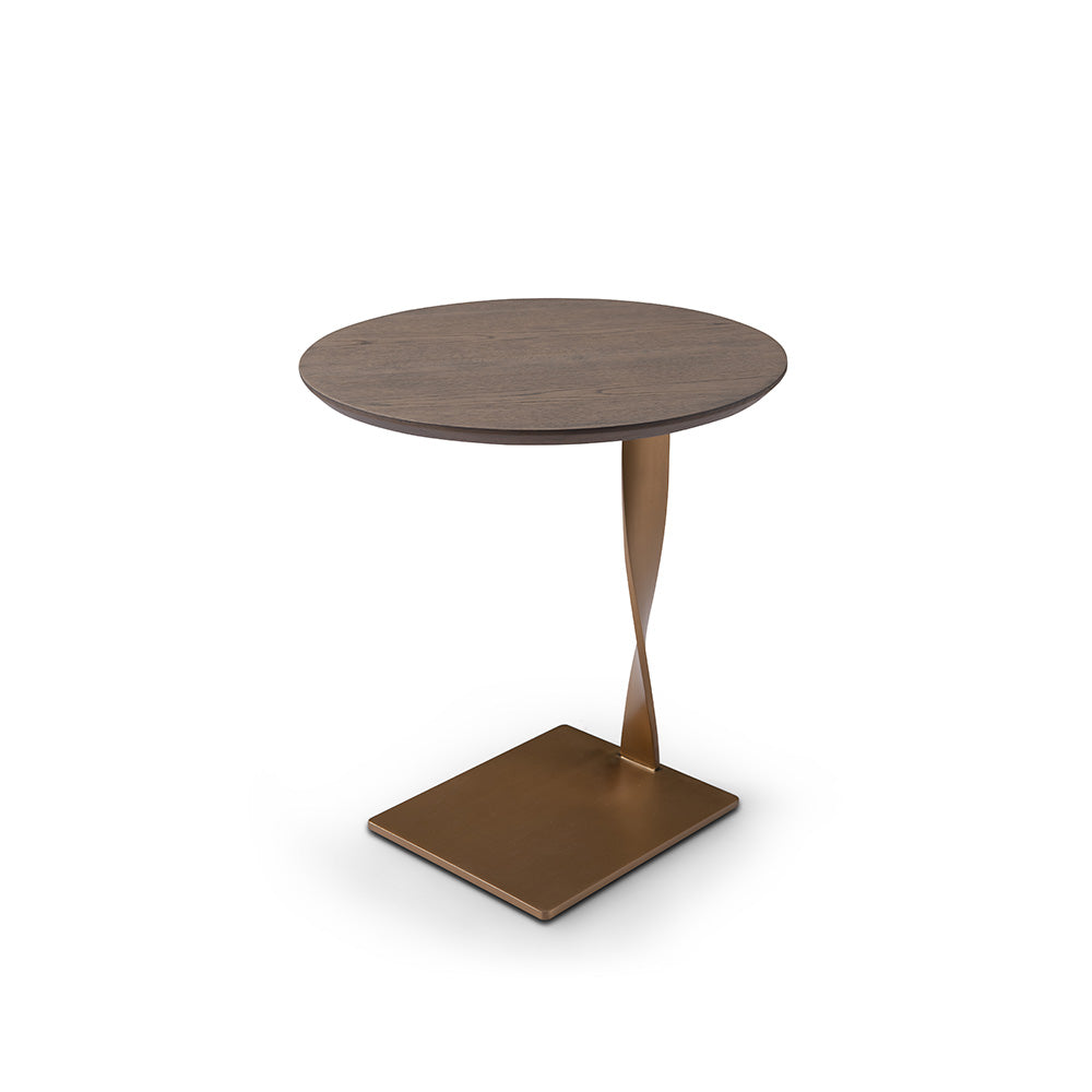 Stylish accent table made with brushed brass and light wood veneer, placed beside a modern armchair in a minimalist interior.
