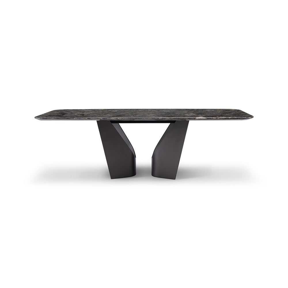 Close-up of the Otto Dining Table showing its diamond marble countertop with natural veining and the bold black base in a modern dining room.