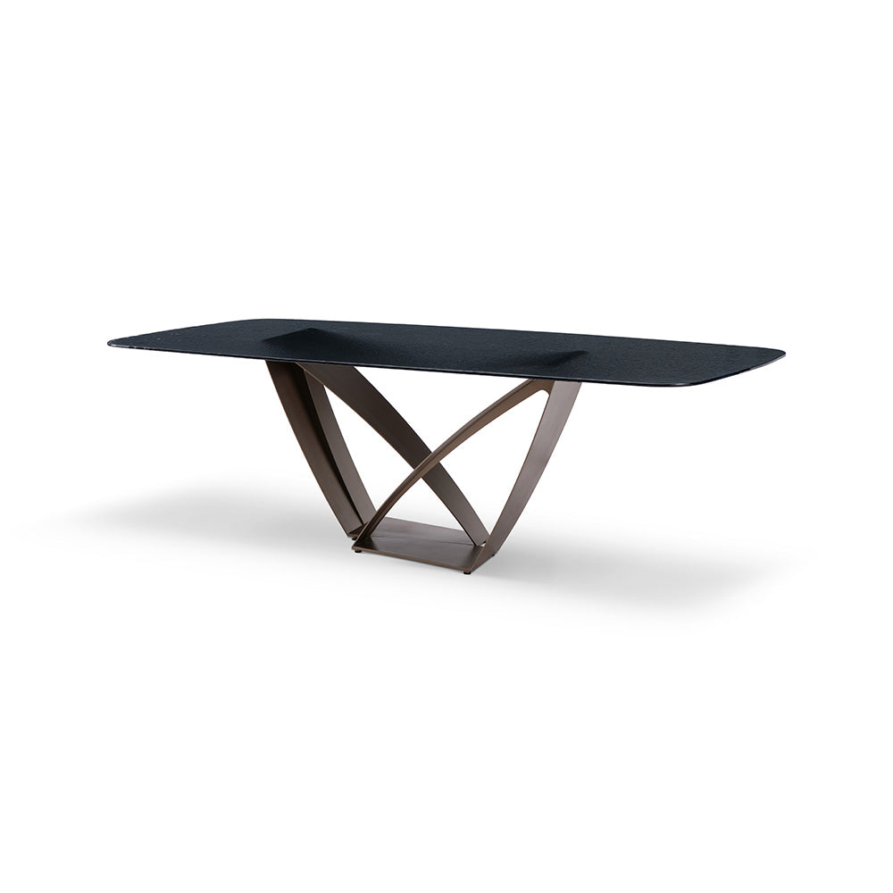 The Byron Dining Table featuring a sculptural brass metal base and smooth glass tabletop, styled in a contemporary dining room.