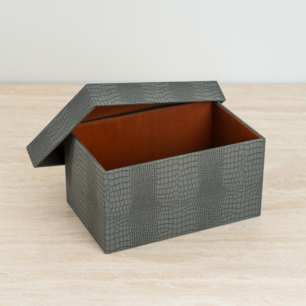 Decorative organizer box in dusty blue crocodile texture with bold orange velvet inside