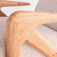 Statement luxury armchair in grey chenille with curved silhouette and solid Elm wood legs, ideal for modern interiors.