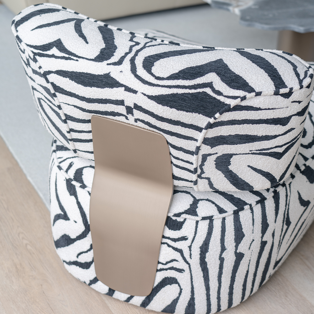 Close-up of zebra pattern fabric on Ryeland Accent Chair and the brushed bronze accent