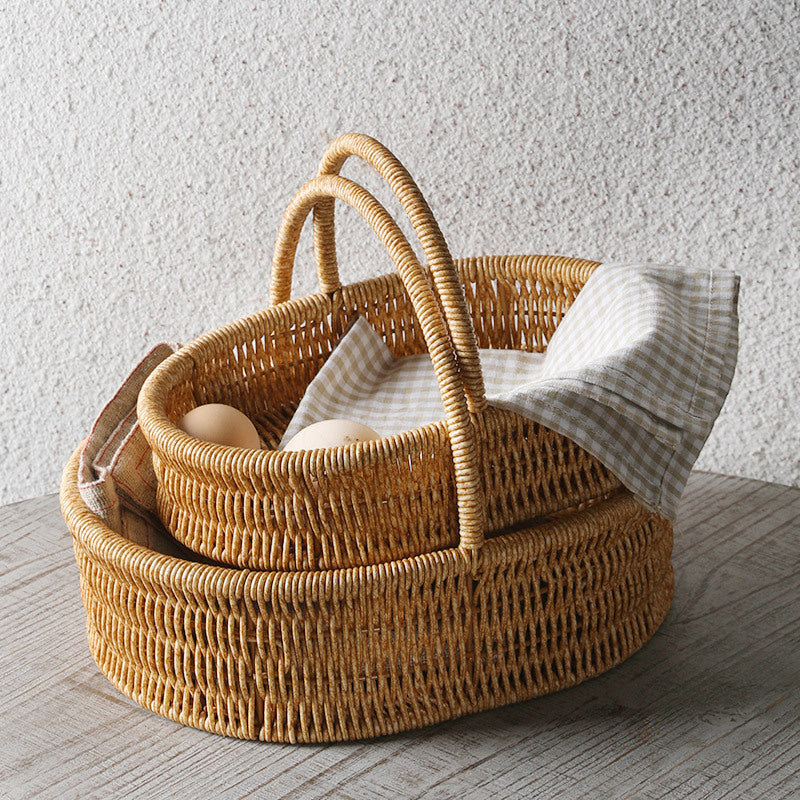 Shallow oval storage basket crafted from durable plastic rattan with a single sturdy handle, perfect for home storage and decoration.