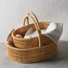 Shallow oval storage basket crafted from durable plastic rattan with a single sturdy handle, perfect for home storage and decoration.