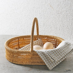 Stylish oval storage basket with a single handle, blending timeless design and functionality for modern homes.