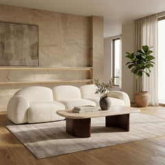 Modern living room with a white sofa, wooden coffee table, and decorative elements.