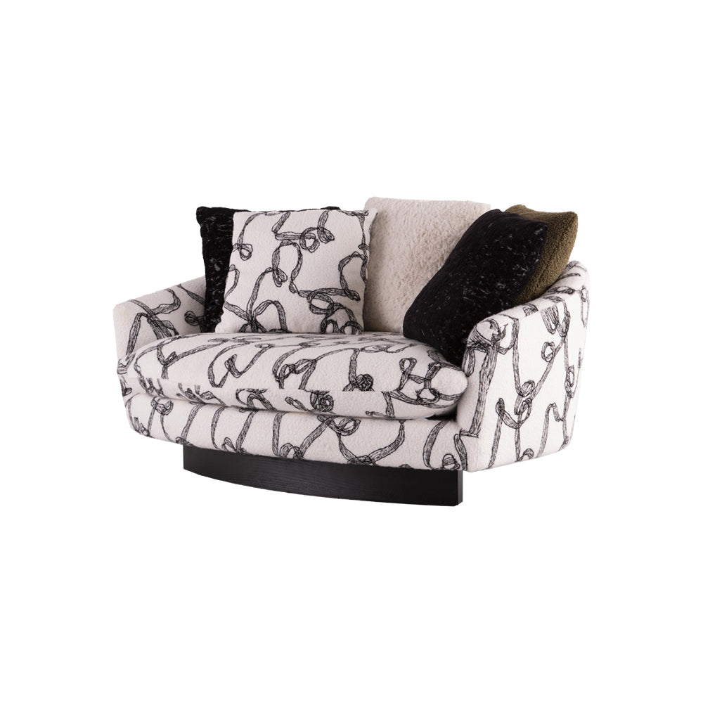 Compact designer lounge sofa upholstered in black-and-white abstract boucle fabric with plush scatter cushions for contemporary interiors.