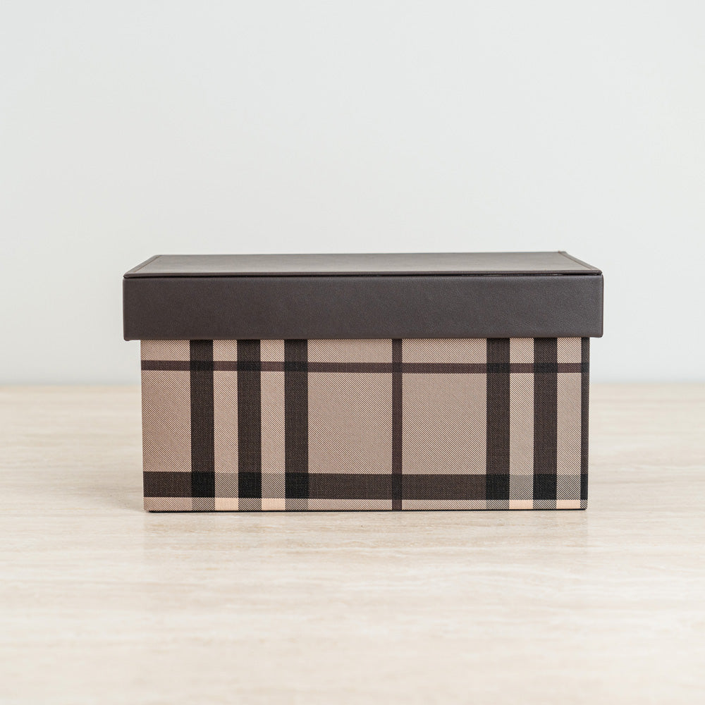 Plaid storage box in warm beige and brown tones with a sleek dark lid for stylish organization