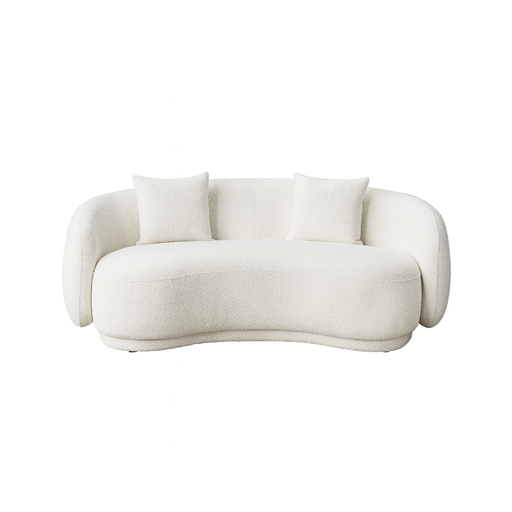The Zoi 2-Seater Sofa in soft white bouclé fabric, featuring a smooth curved silhouette and two matching cushions, styled in a bright contemporary living room.