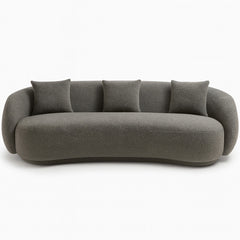 The Zoi 3-Seater Sofa in elegant grey bouclé upholstery, showcasing its modern curved silhouette and plush cushions in a minimalist, contemporary space.