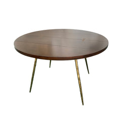Angers Dining Table with a round brown-stained Ashwood top and forged iron legs, combining mid-century modern warmth with artisan metal craftsmanship.