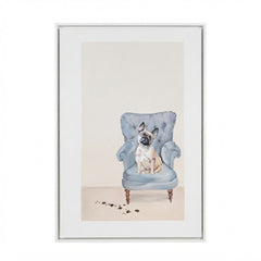 A framed art print featuring a watercolor-style illustration of a fawn dog sitting in a light blue armchair, with a white mat and thin frame on a white background.