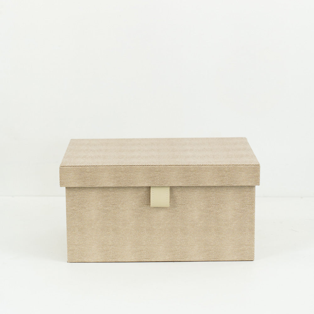 Multiple Isla PU leather storage boxes in various sizes, arranged on a shelf in a minimalist setting