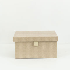 Multiple Isla PU leather storage boxes in various sizes, arranged on a shelf in a minimalist setting
