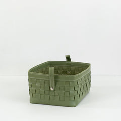 Kara leather storage basket in brown, filled with magazines and toys, placed in a modern living room