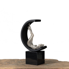 Luxury home decor sculpture featuring a poised figure within a half-circle ring on a black stand, combining classical artistry and modern design elements.