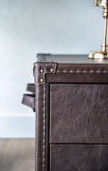 Luxury coffee table crafted in top-grain leather with vintage-style handles and riveted detailing, functional and stylish