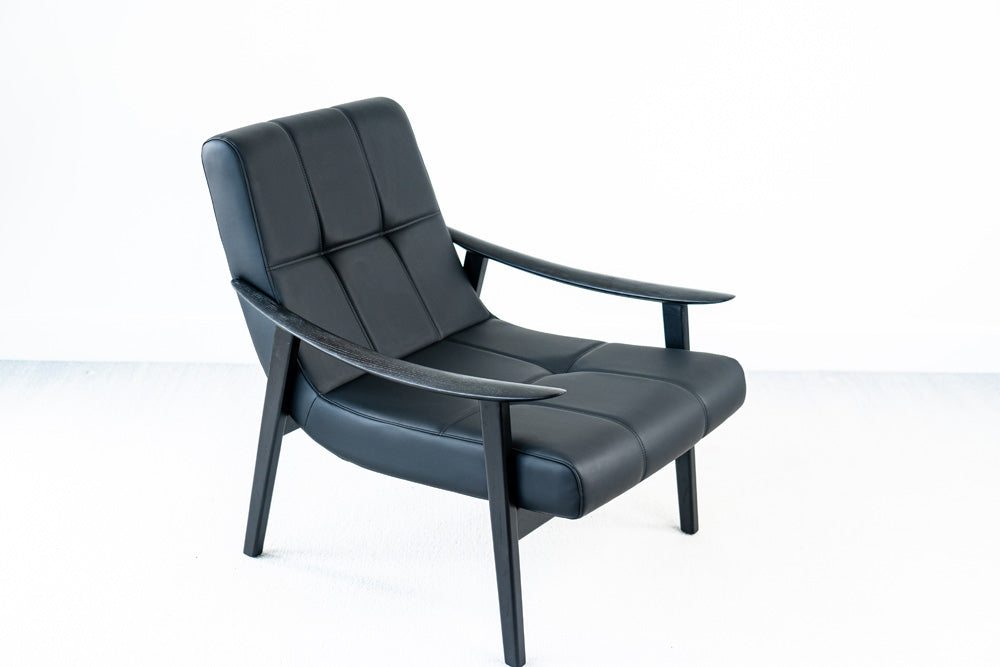 Modern black Trani lounge chair with faux leather upholstery and wooden base, stylish accent chair