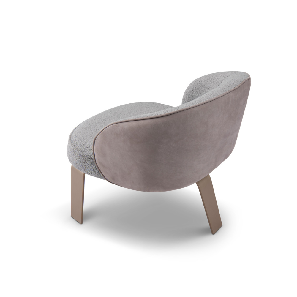 Luxury Orvieto Bouclé Armchair with smooth leather back and brass-colored legs, combining soft texture and bold contrast for contemporary interiors.