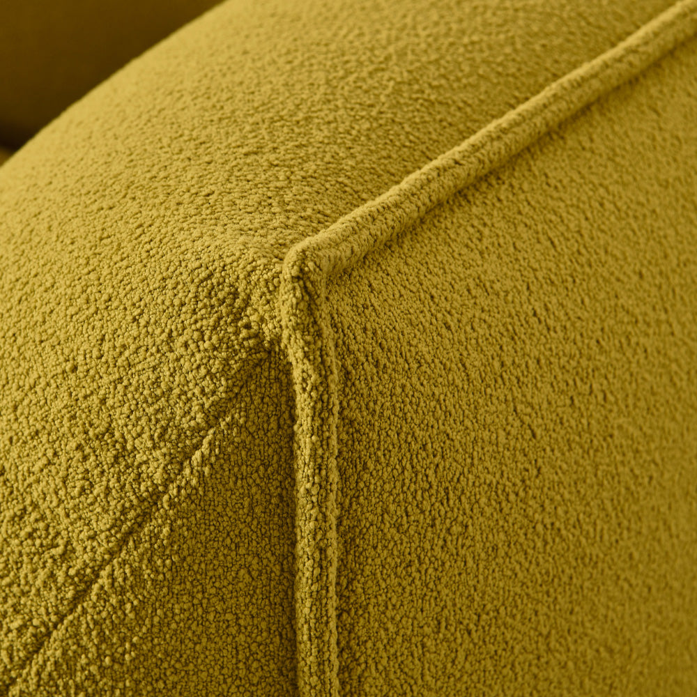 Panos Modern Fabric Armchair in vibrant yellow upholstery, featuring a soft cushioned seat and sculptural modern design for contemporary living rooms.