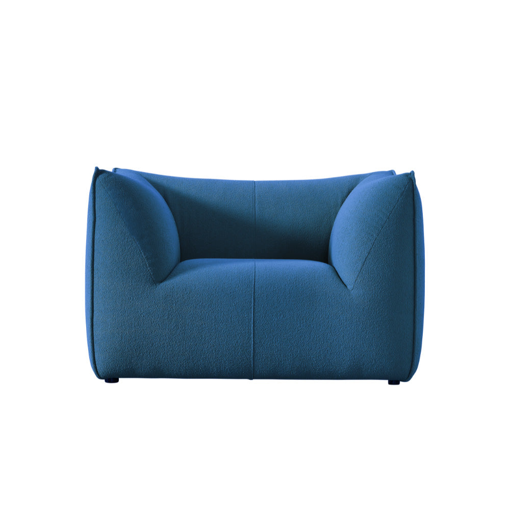 Blue Panos Contemporary Lounge Chair with plush upholstery and curved silhouette, ideal for modern studio spaces and cozy living areas.