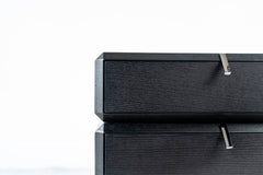 Rotating bedside table in black finish with three drawers, modern swivel nightstand with storage